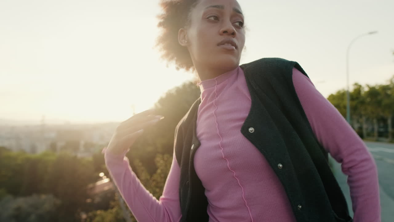 Young Woman Dances on Rooftop at Sunset