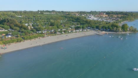 Boats-and-swimmers-play-in-the-Ocean-next-to-a-massive-campsite-on-the-beach