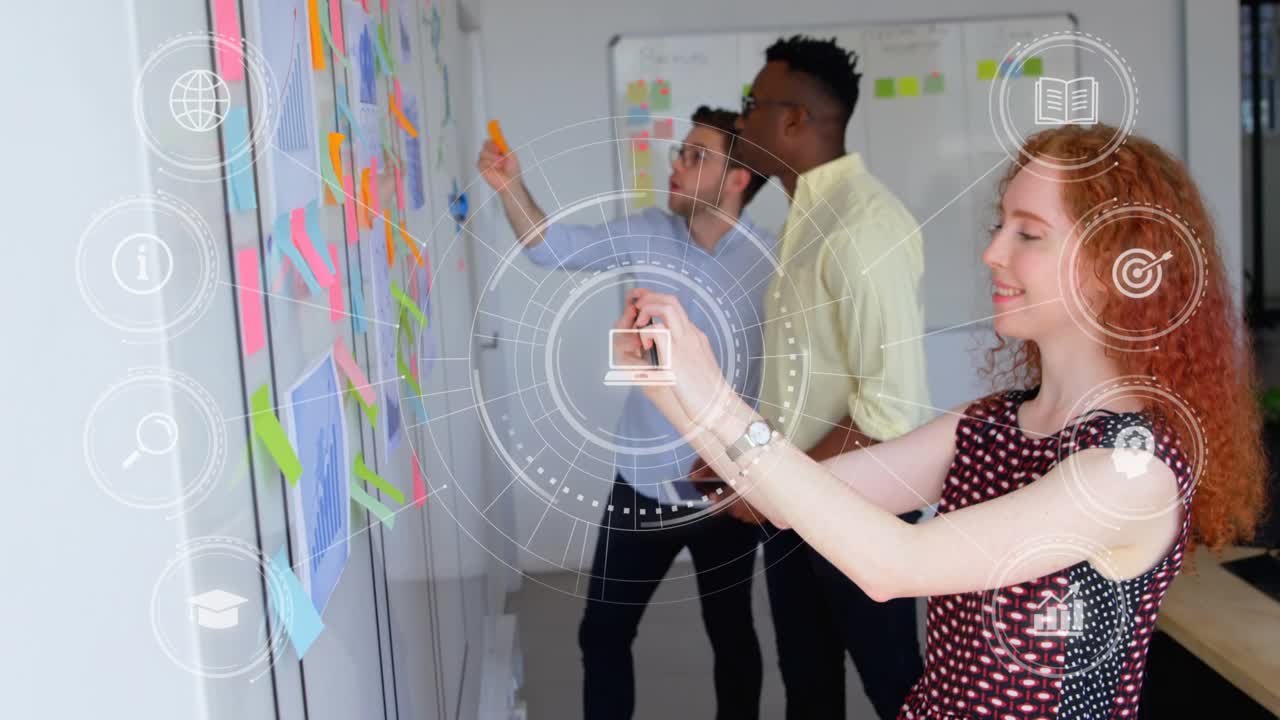 Team pointing, rearranging note wall for business, filming by phone while HUD highlighting laptop