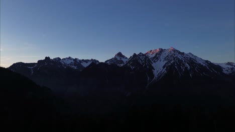 aerial drone flight early morning in the austrian alps, beautiful mountain landscape surrounded by forest