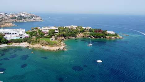 Boats-drift-in-the-sea-in-front-of-a-resort-in-Agia-Pelagia,-Crete