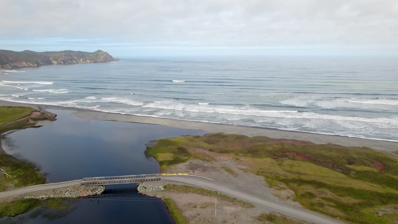 Luftfoto av Cucao med strendene på Chiloé på en overskyet dag og naturlige og uberørte jorder