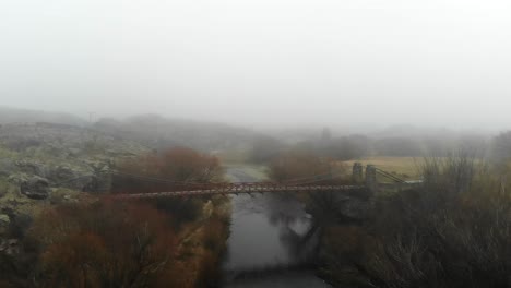 Flyover-up-Manuherikia-River-looking-down-on-historic-Daniel-O'Connell-Bridge-near-to-Ophir-town-in-Central-Otago