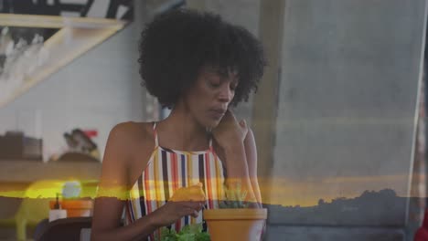 animación del paisaje del atardecer sobre una mujer afroamericana comiendo ensalada.