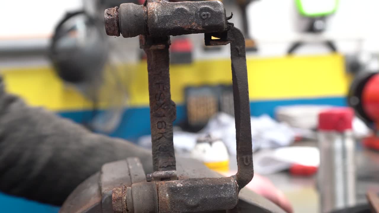 un técnico lubricando un deslizador de freno y asegurándose de que se mueva libremente