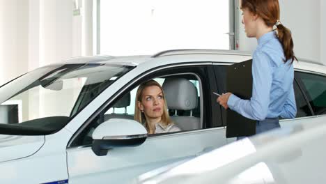 woman discussing car purchase with salesperson