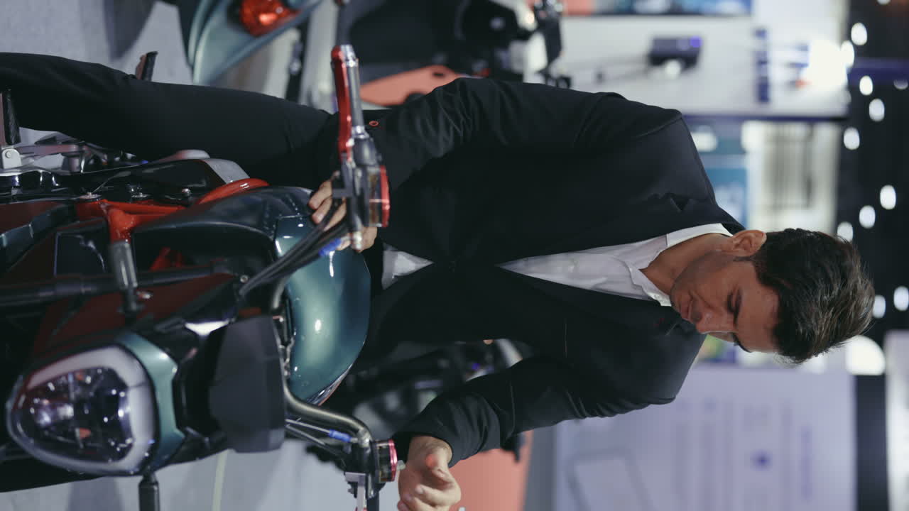 Businessman Examining a Green Motorcycle at an Exhibition