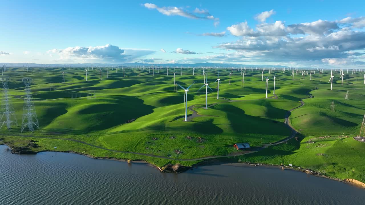 캘리포니아 몬테주마 힐스 구불구불한 녹색 언덕이 있는 강을 따라 청정 에너지를 생산하는 풍력 터빈 농장