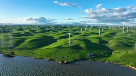 wind turbine farm producing clean energy along river with rolling green hills, montezuma hills california