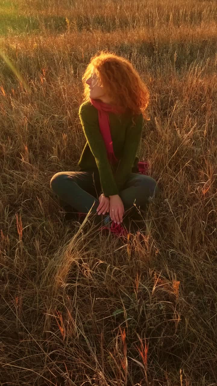 Donna che si rilassa in un campo al tramonto