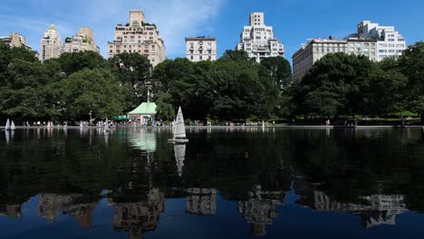 tourists at central park pond in manhattan on a summer day in new york city