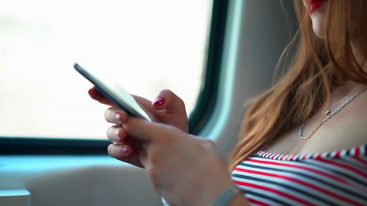 mujer atractiva usando teléfono inteligente en un tren en movimiento. 4k (uhd