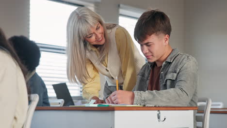 teacher helping student in classroom
