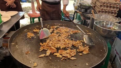 cooking and serving a crispy street food dish.