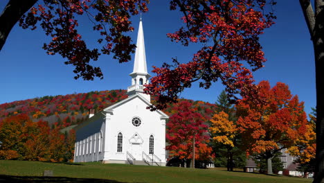 white church with steeple amidst vibrant autumn foliage