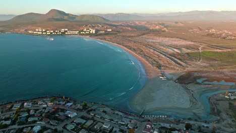 vista aérea panorámica de la playa de socos en el norte de chile, con edificios y casas solitarias en las montañas a los lados, día soleado