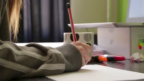 woman at a desk writing on a sheet of paper tilt