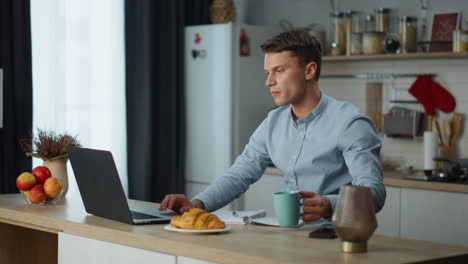 man working laptop kitchen with fresh coffee. businessman searching information.