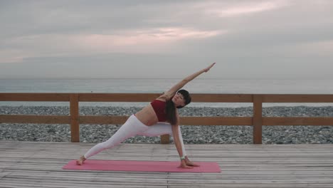 woman practicing yoga on the beach