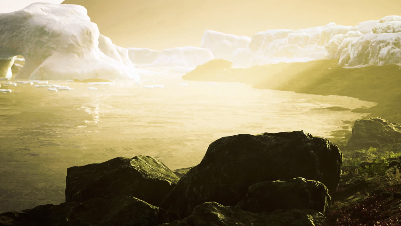 Golden sunlight reflects on icy cliffs beside a tranquil water body at dusk