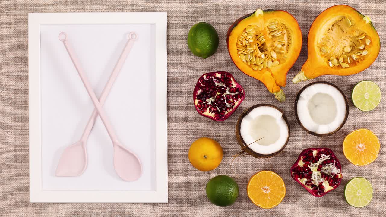 조각 된 과일은 주방 테이블에 프레임과 요리 도구와 함께 나타납니다. 움직임을 멈추십시오