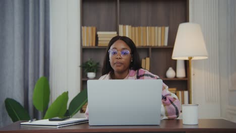 mujer trabajando en una computadora portátil en casa