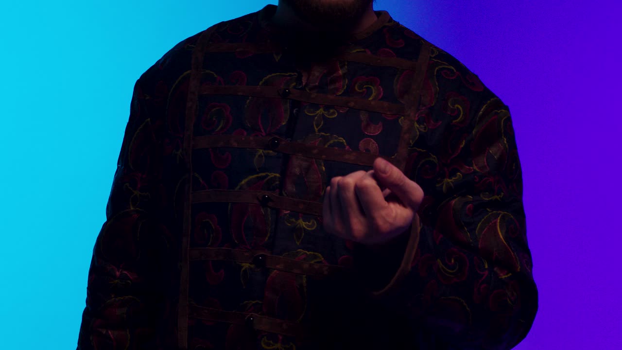 전통 의복 을 입은 남자 가 가리키는 몸짓 을 하고 있다