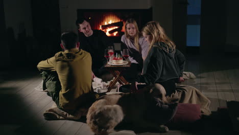 amigos celebrando su cumpleaños junto a la chimenea.