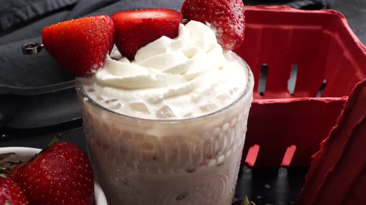 Pink cocktail drink with strawberry liqueur, vanilla vodka and cream. Party drink with strawberries. Fruit cocktail with fresh strawberries as a garnish. Cold and refreshing