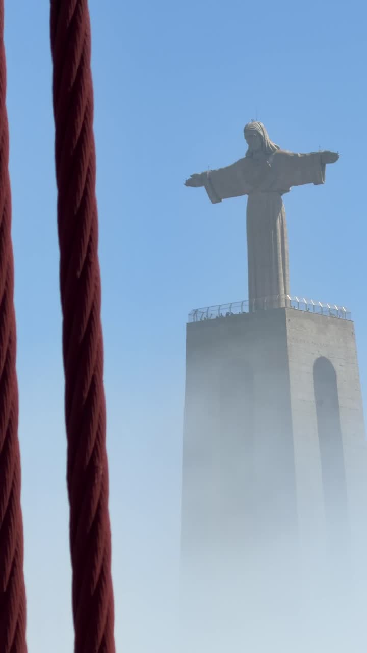 Iconica statua del Cristo Re a Lisbona che emerge dalla nebbia.