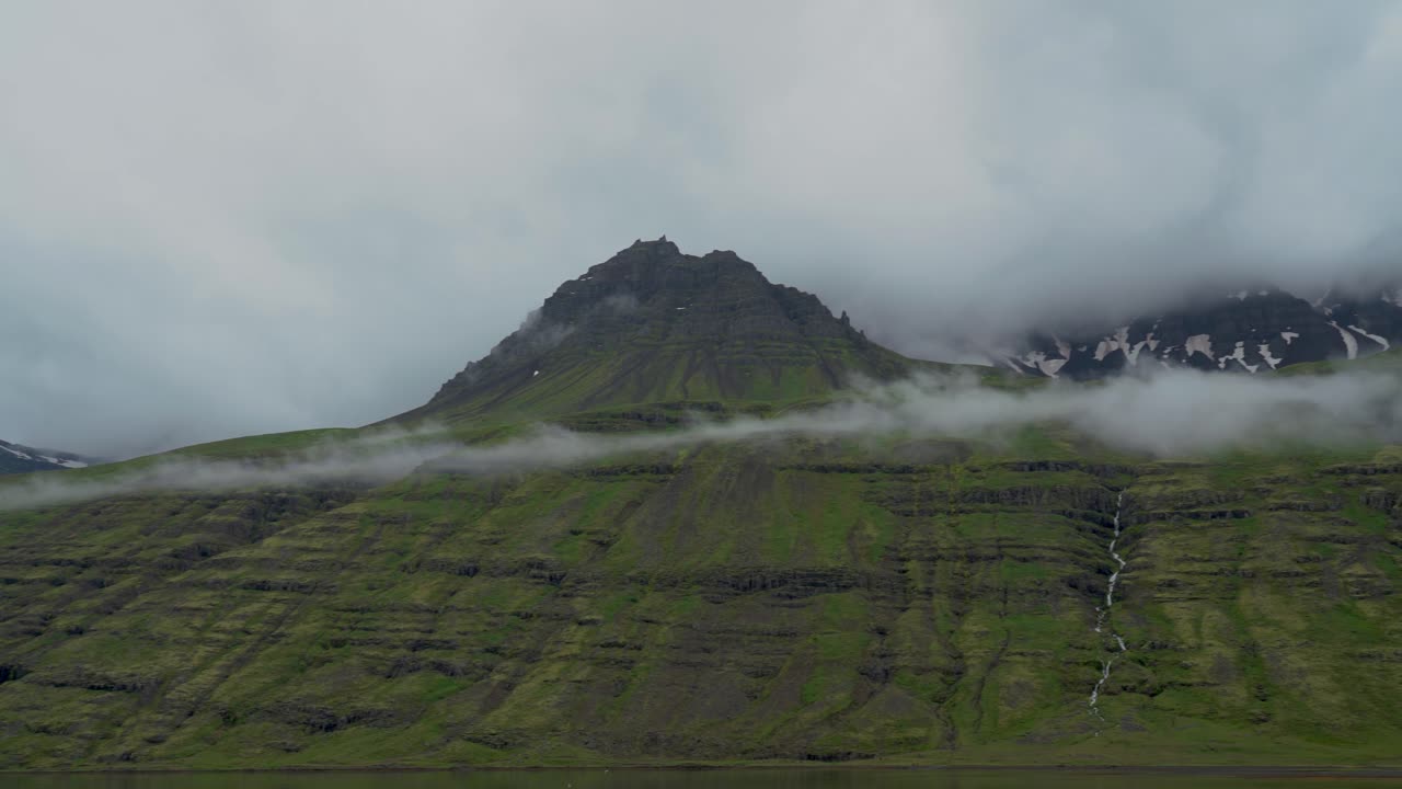 회색 하늘 동안 구름과 안개로 덮인 아이슬란드 산맥의 파노라마 샷
