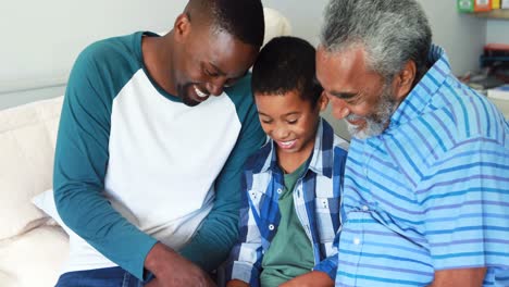 Multi-generation-family-using-digital-tablet-on-bed