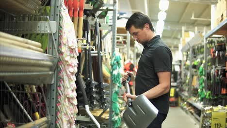 hombre comprando herramientas de jardinería en una ferretería
