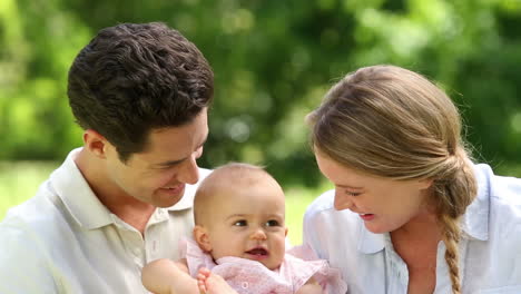 happy parents with their baby girl in the park