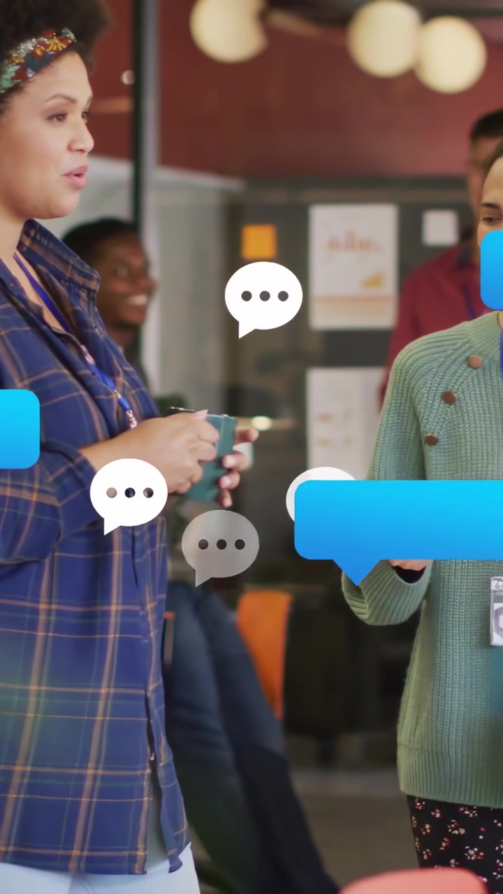 Vídeo vertical: Mulher entrando segurando uma caneca azul-petróleo, iniciando bolhas de chat no escritório para uma conversa informal
