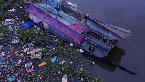 Aerial-drone-shot-passing-over-A-sunken-and-abandoned-House-boat-in-a-Canal-of-Ho-Chi-Minh-City-Vietnam