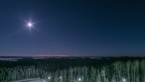 Glowing-full-moon-rolling-on-night-sky-over-winter-landscape-and-city,-fusion-time-lapse