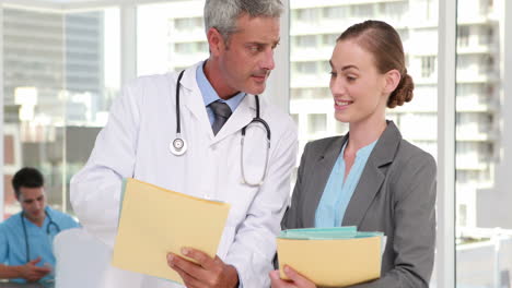 Two-doctors-looking-at-camera-with-their-colleagues-behind-