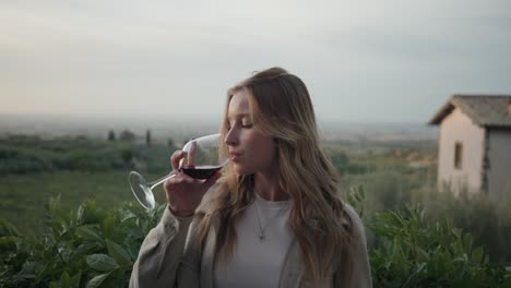 beautiful blond woman drinking red wine with nature background