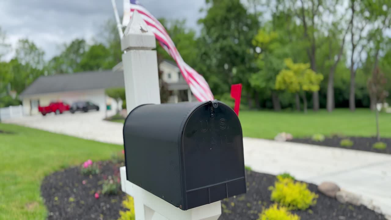 Flag flapping behind a black mailbox. Slowed to half speed