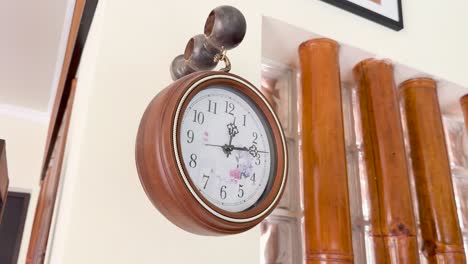 a vintage wooden clock hangs in a well-lit clifftop restaurant in phuket, thailand, with bamboo decor and a serene ambiance