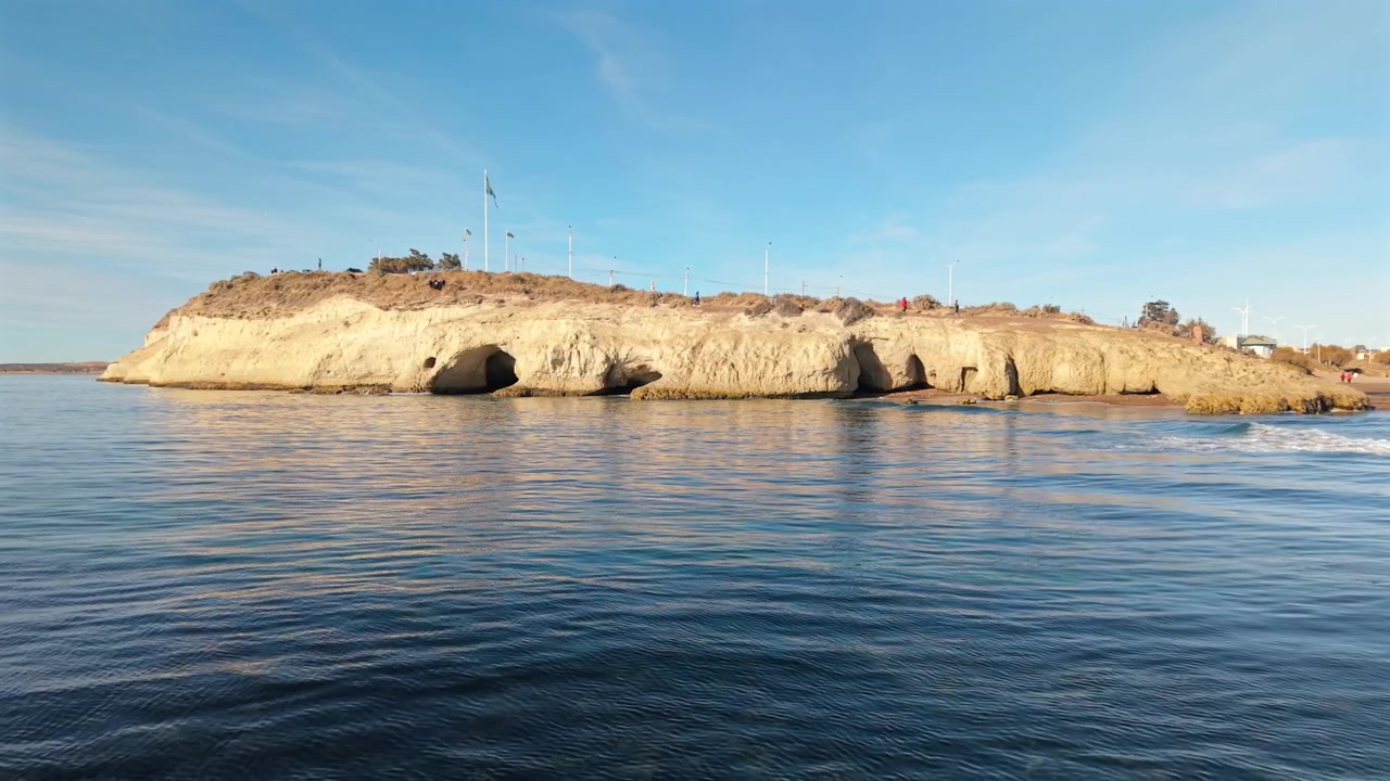 Rannikkokalliot ja meriluolat Punta Cuevasissa lähellä Puerto Madrynia, Chubutia, Argentiinaa, Patagonian Etelä-Atlantin rannikolla, tyynen valtameren ja merigeologian kera, droonin ilmakuva eteenpäin liikkuen.