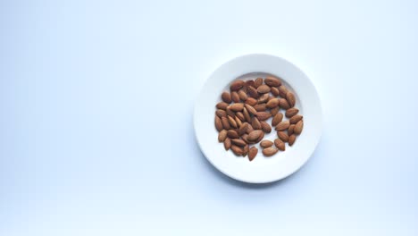 la mano del niño alcanzando las almendras en un plato