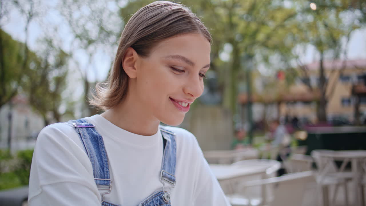 Joyful lady messaging laptop at street restaurant closeup. Smiling woman at cafe