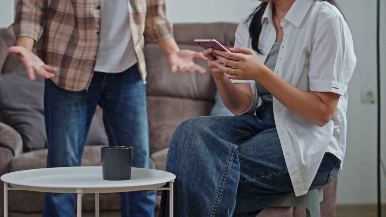 Husband shows divorce papers to indifferent wife distracted by her phone
