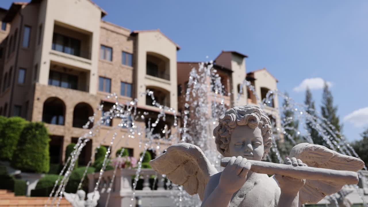 estatua de un ángel con chorros de agua en el fondo