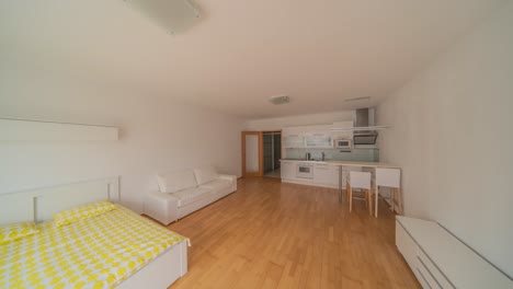 Ein-Elegantes-Studio-Apartment-Mit-Luftiger-Atmosphäre,-Eleganten-Weißen-Möbeln-Und-Einer-Modernen-Küche