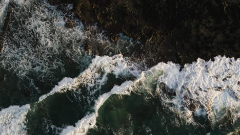 Satellitenansicht-Von-Oben-Nach-Unten-Auf-Wellen,-Die-Gegen-Felsen-Am-Sandstrand-Von-Oahu,-Hawaii,-Krachen