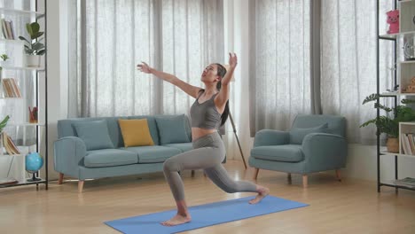 joven atleta asiática haciendo ejercicio, estirándose y practicando yoga en la alfombra en casa