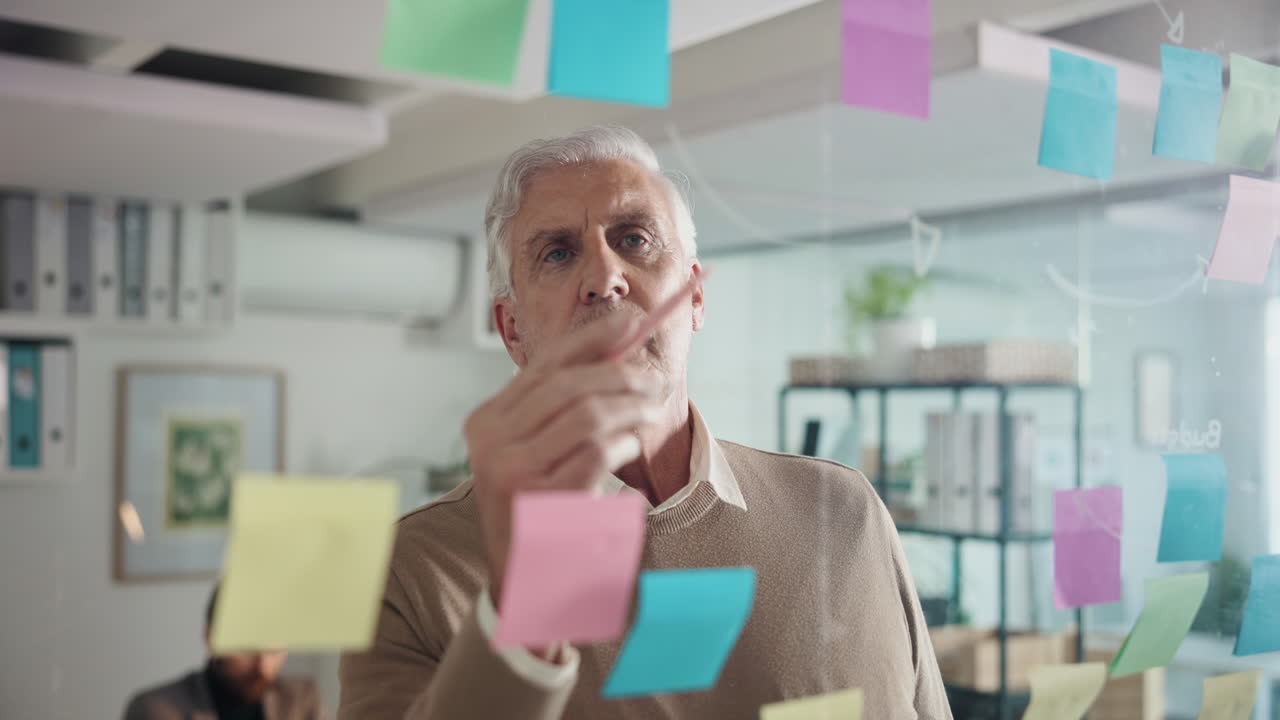 Senior Man Brainstorming with Sticky Notes in Office